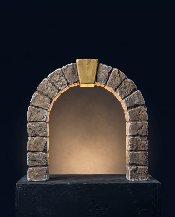 The arch complete, gold at the crown, light coming through the opening.